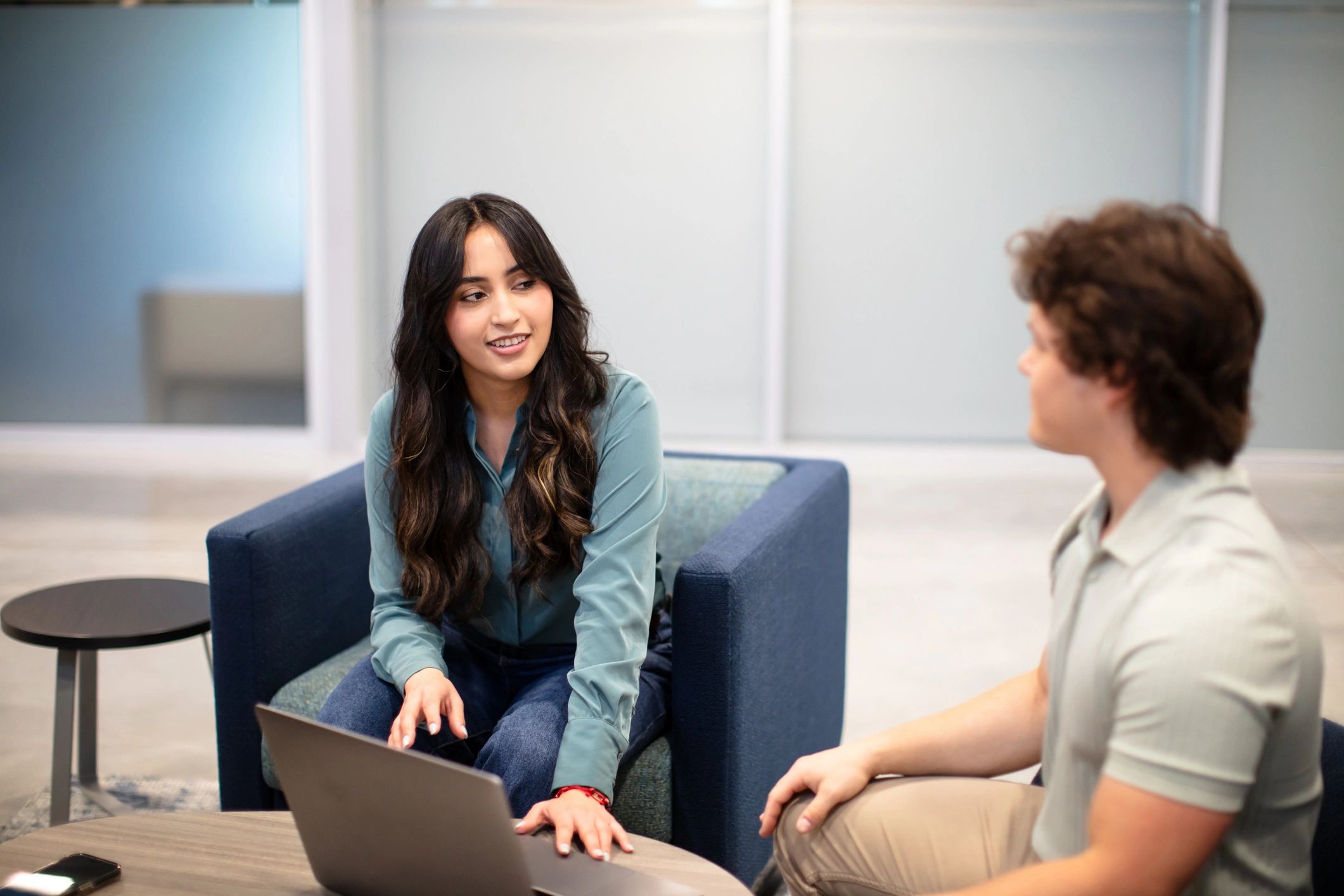 Two professionals discussing work in a co-working space